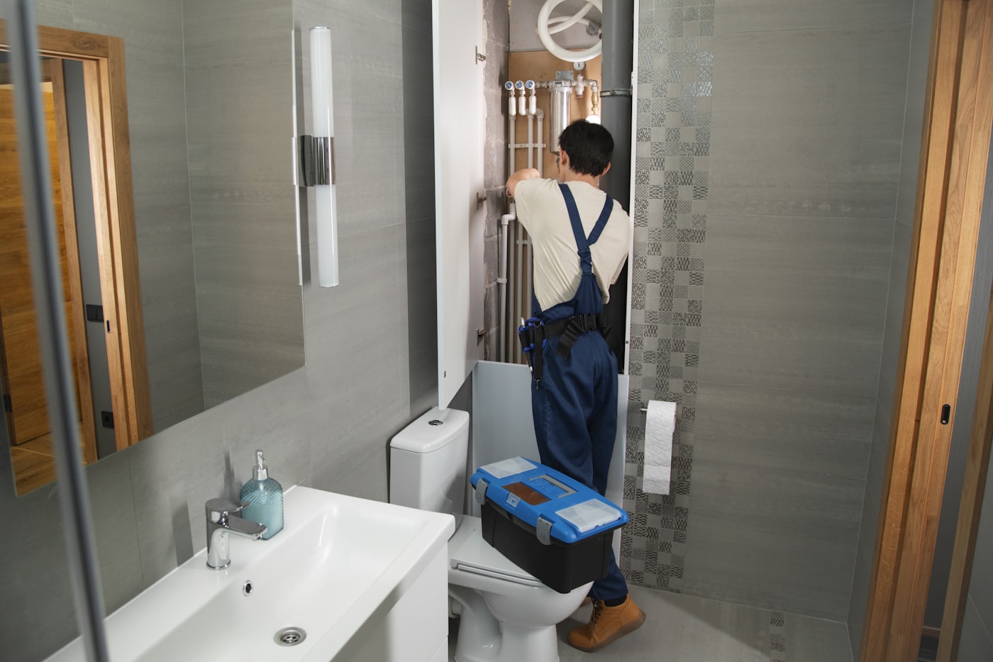 Plumber working on pipework in a bathroom